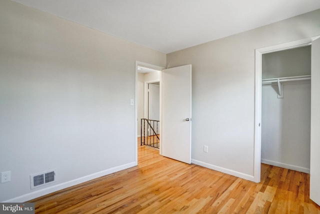 unfurnished bedroom featuring a closet and light wood-type flooring