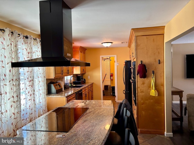 kitchen with sink, island exhaust hood, light tile patterned floors, black appliances, and light stone countertops