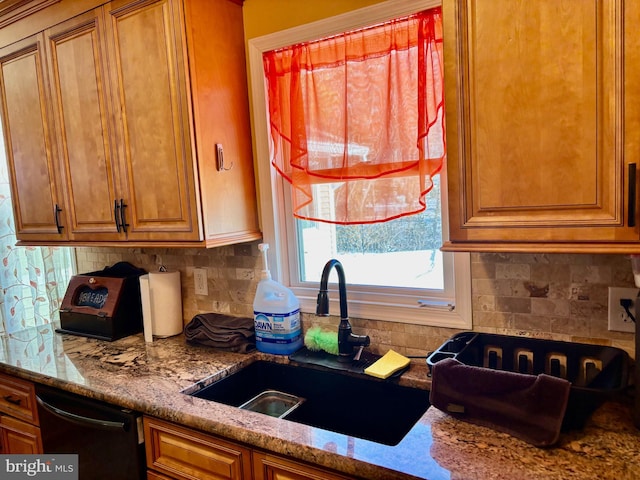 kitchen with light stone counters, sink, tasteful backsplash, and dishwasher