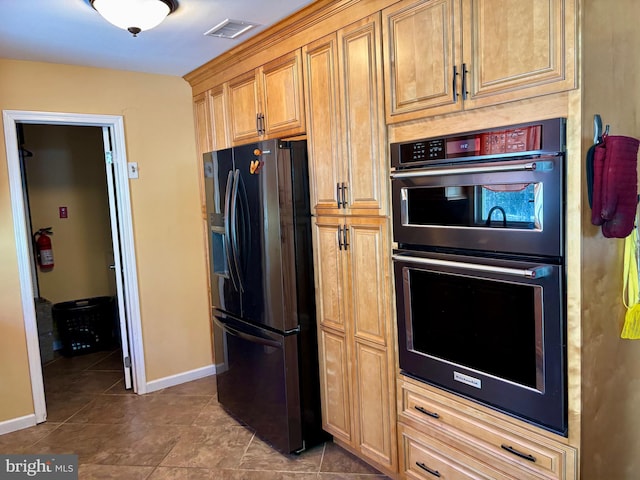 kitchen featuring black fridge, tile patterned floors, and double wall oven