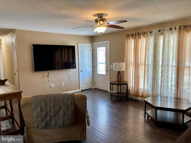 living room featuring ceiling fan, dark hardwood / wood-style floors, and a textured ceiling