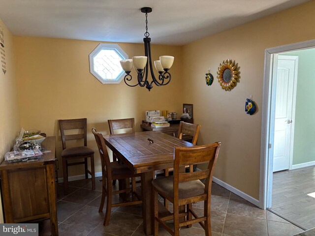 tiled dining room with a notable chandelier