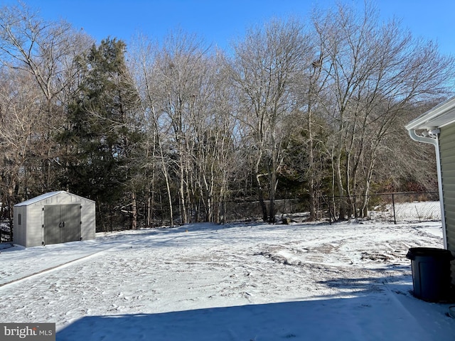 yard covered in snow featuring a storage unit