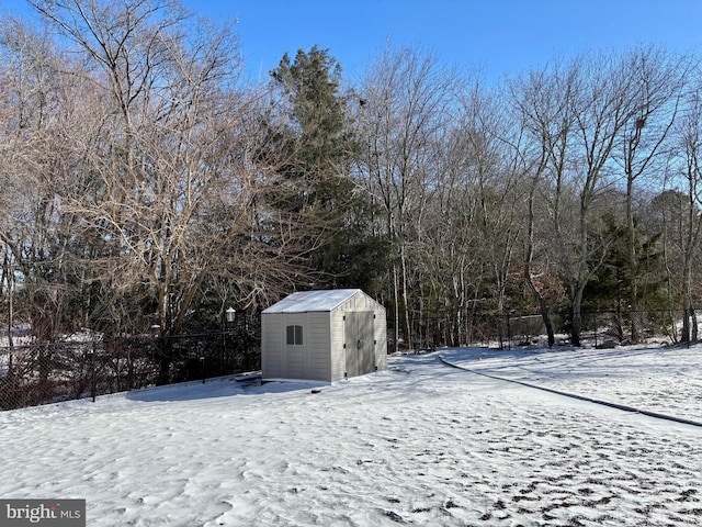 yard covered in snow featuring a storage unit