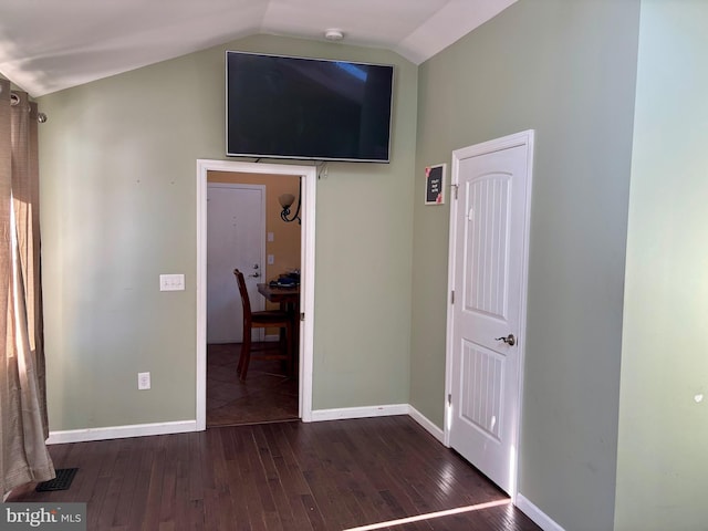 unfurnished bedroom featuring lofted ceiling and dark hardwood / wood-style floors