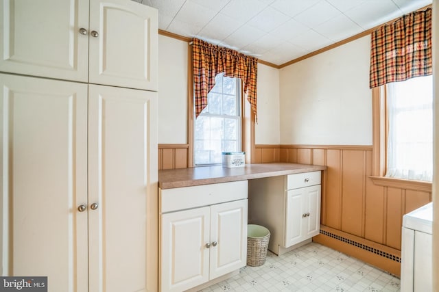 interior space featuring crown molding and a baseboard heating unit