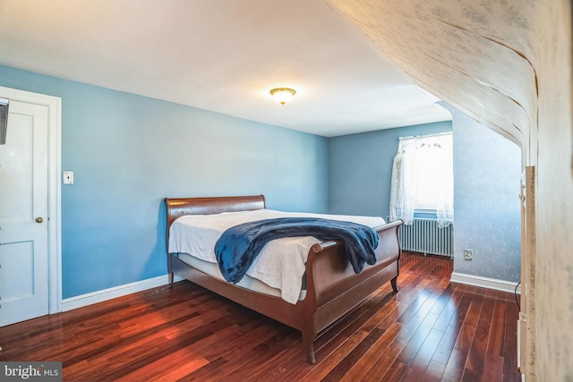 bedroom with radiator heating unit and dark hardwood / wood-style flooring