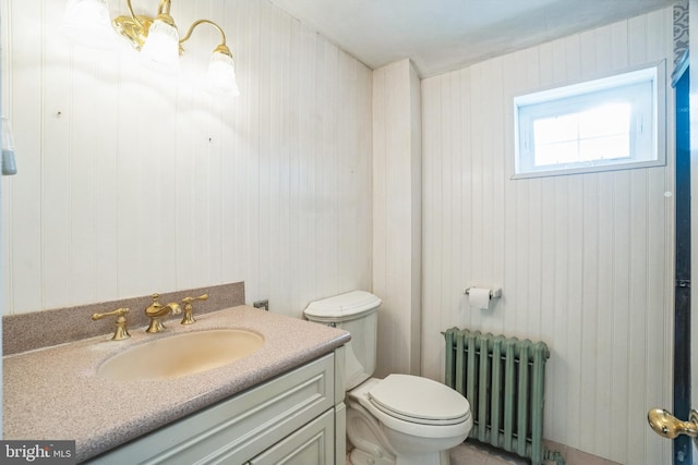 bathroom with vanity, toilet, and radiator