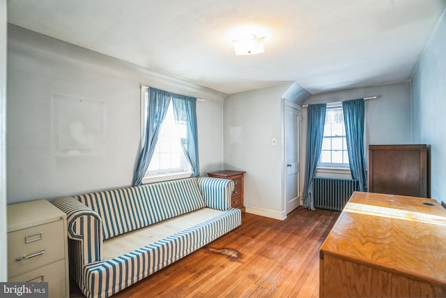 living area with hardwood / wood-style flooring, a healthy amount of sunlight, and radiator