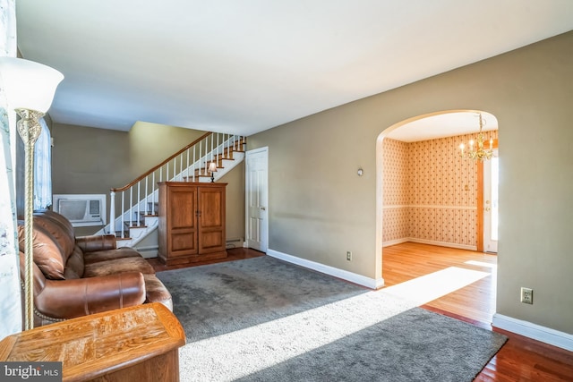 living room featuring dark hardwood / wood-style floors, an inviting chandelier, a baseboard radiator, and a wall mounted AC