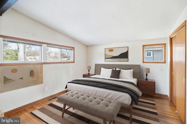 bedroom with vaulted ceiling and light wood-type flooring