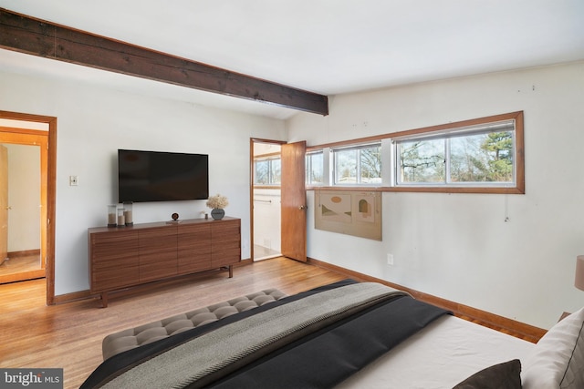 bedroom featuring lofted ceiling with beams and light hardwood / wood-style floors