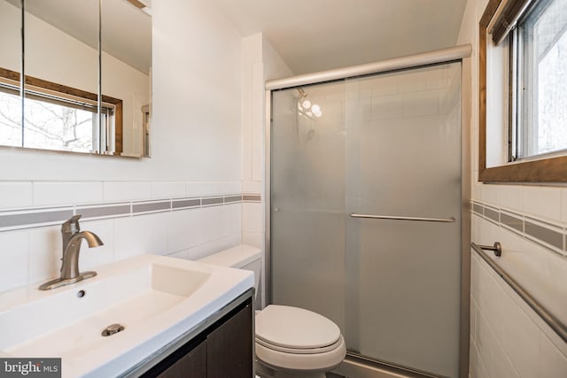 bathroom featuring vanity, toilet, an enclosed shower, and tile walls