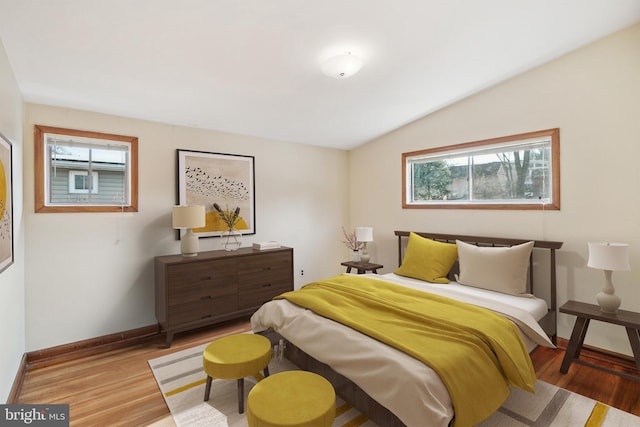 bedroom with light hardwood / wood-style floors and lofted ceiling