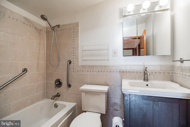 full bathroom with tiled shower / bath combo, toilet, tile walls, and vanity