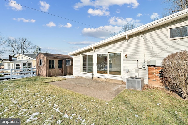 back of house with a storage shed, a yard, a patio, and central AC