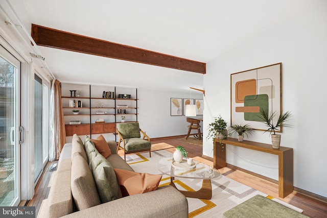 living room featuring beamed ceiling and light hardwood / wood-style flooring