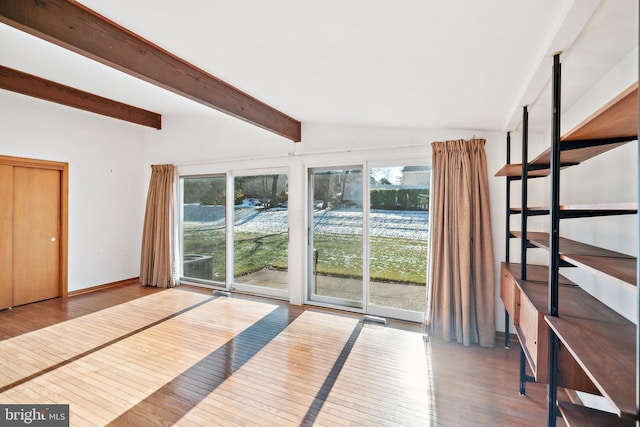 interior space featuring wood-type flooring and vaulted ceiling with beams