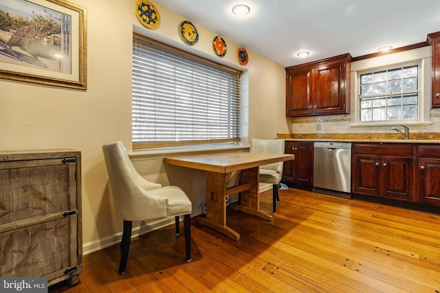 kitchen with decorative backsplash, sink, dishwasher, light hardwood / wood-style floors, and plenty of natural light