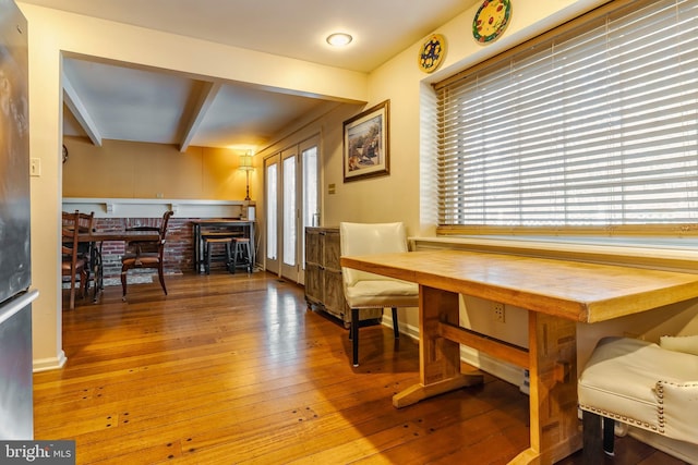 dining area with beam ceiling, hardwood / wood-style flooring, and a wealth of natural light