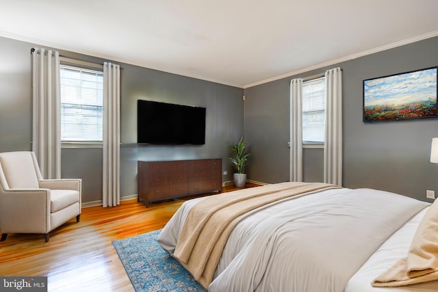 bedroom featuring ornamental molding and light wood-type flooring