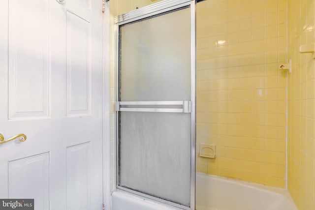 bathroom featuring bath / shower combo with glass door