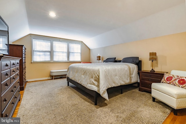 bedroom featuring light hardwood / wood-style floors and lofted ceiling