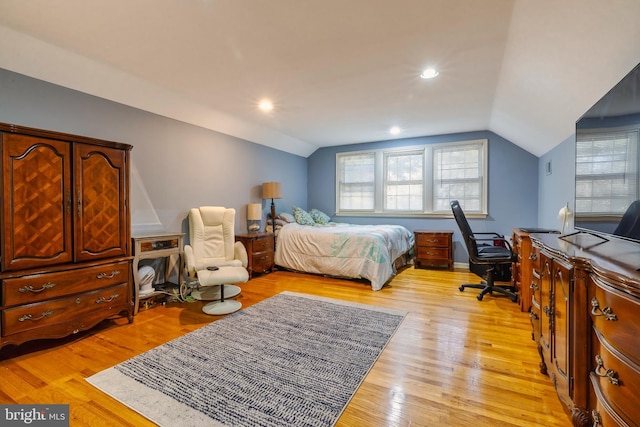 bedroom with light hardwood / wood-style floors and lofted ceiling