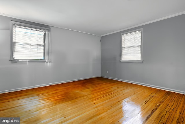 empty room featuring crown molding and light hardwood / wood-style flooring