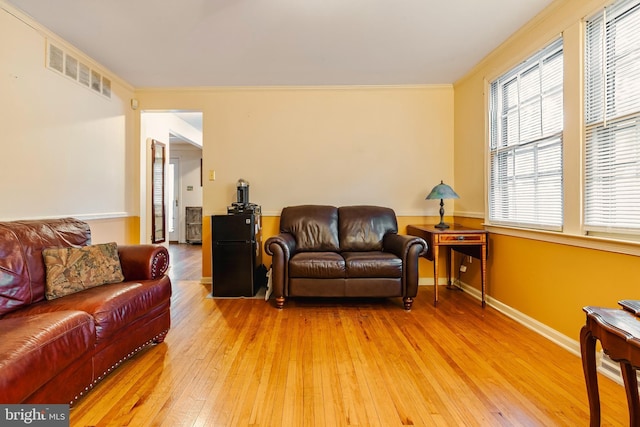 living room with light hardwood / wood-style floors and ornamental molding