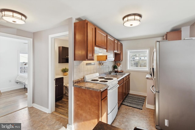 kitchen featuring decorative backsplash, stainless steel fridge, light wood-type flooring, white electric range oven, and sink