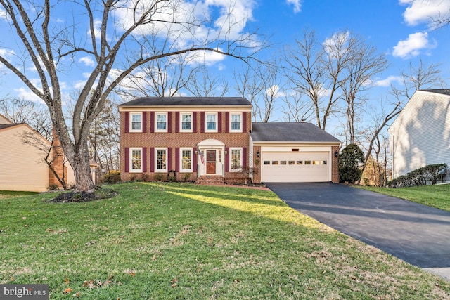 colonial home featuring a front yard and a garage