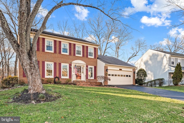 colonial-style house featuring a front lawn and a garage