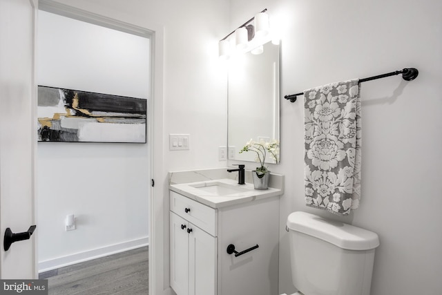 bathroom featuring vanity, wood-type flooring, and toilet