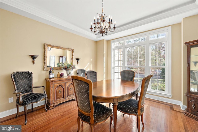 dining room featuring ornamental molding, a chandelier, and light wood-type flooring