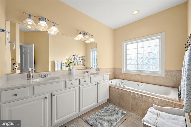 bathroom featuring tiled tub, tile patterned flooring, and vanity