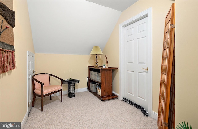 sitting room featuring light carpet and lofted ceiling