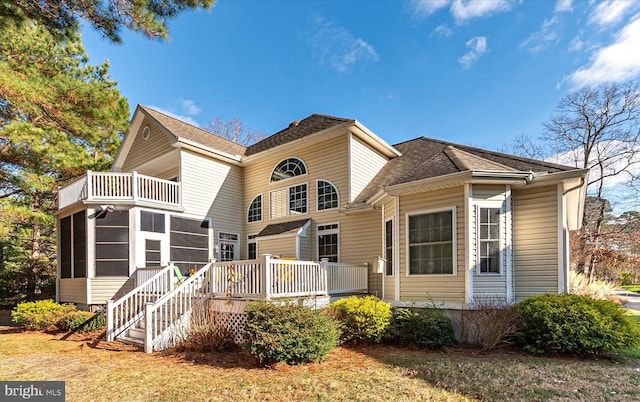 view of front of house with a balcony and a sunroom