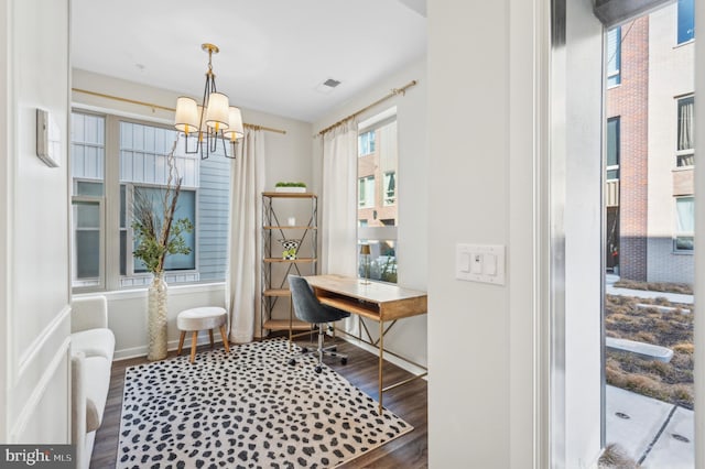 home office with dark hardwood / wood-style floors and a notable chandelier