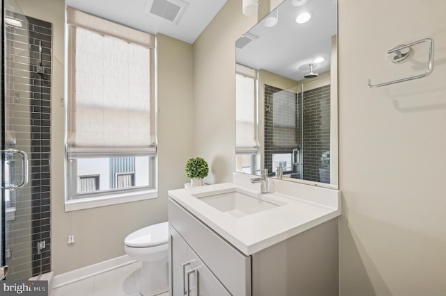 bathroom featuring toilet, a shower with door, tile patterned floors, and vanity