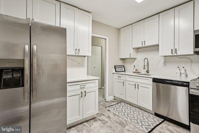 kitchen with backsplash, stainless steel appliances, white cabinetry, and sink