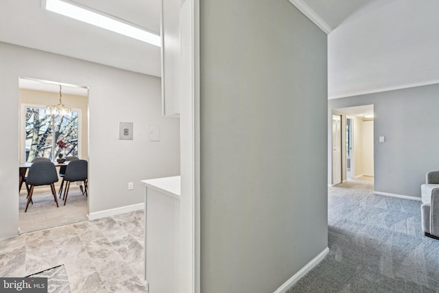 hall featuring ornamental molding and an inviting chandelier