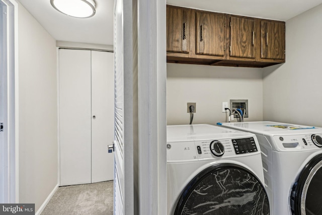 laundry area with light carpet, separate washer and dryer, and cabinets