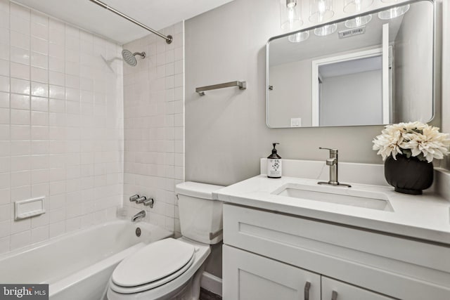 full bathroom featuring vanity, tiled shower / bath combo, and toilet