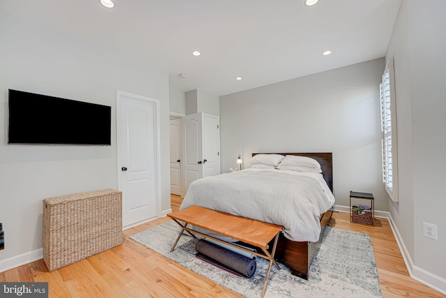 bedroom with baseboards, recessed lighting, and light wood finished floors