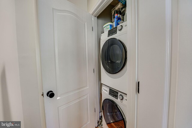 clothes washing area with stacked washer / dryer and laundry area
