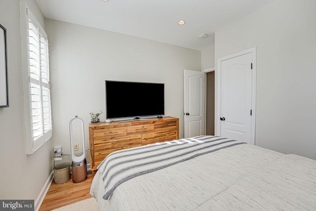 bedroom with baseboards, recessed lighting, wood finished floors, and multiple windows
