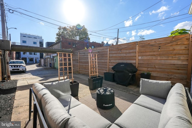 view of patio with outdoor lounge area, grilling area, and fence