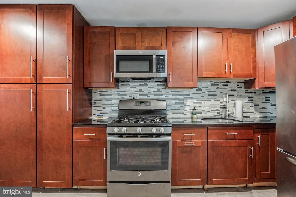 kitchen featuring decorative backsplash, appliances with stainless steel finishes, and sink