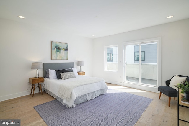 bedroom featuring access to exterior and light wood-type flooring